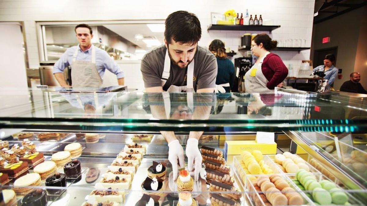Daniel Benjamin, center, arranges baked goods in lucettegrace on Dec. 29, 2014.
