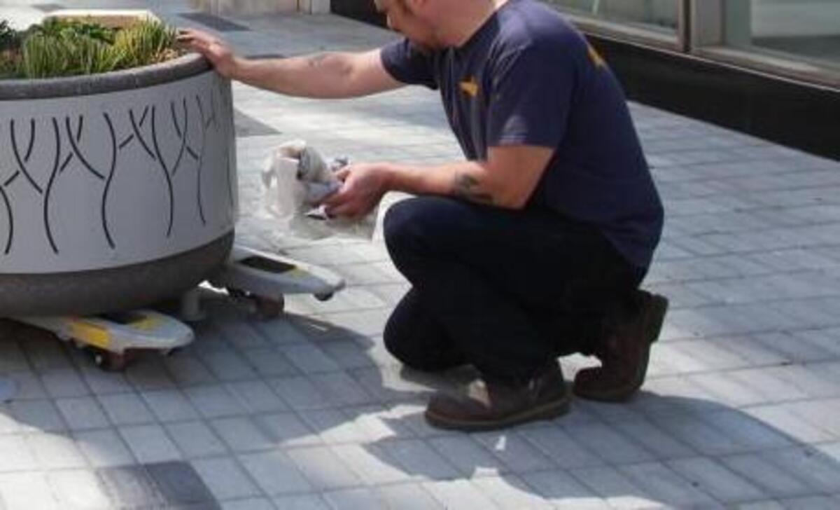 McConnell Studios fabricator Richard Rose, left, moves a newly finished planter in Exchange Plaza with project manager Drew Stowell on April 26, 2016.