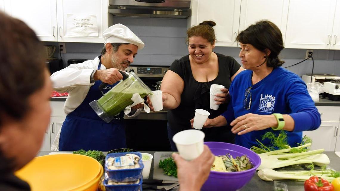 Instructor Dilap Barman, left, pours samples of a green smoothie for Blanca Perez and Maria Martinez at Alliance Medical Ministry in Raleigh. The group gathered recently for a six week Cooking Matters course to learn about nutrition and making healthy, affordable meals.