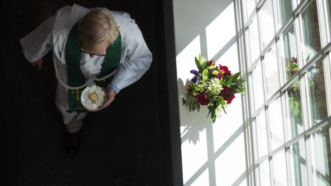 
Associate Rector Reverend David Cumbie carries a dish for communion during the inaugural service on Sunday, September 13, 2015 at Holy Trinity Anglican Church in downtown Raleigh.
