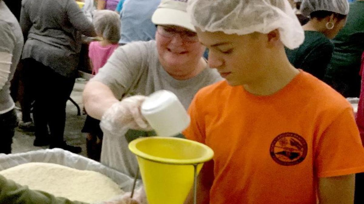 Sara Gilbert, of Apex, left, and Benjamin Roark package food Saturday at the Stop Hunger Now relief event in Raleigh. Gilbert volunteered at the event to mark her 50th birthday and help the relief agency.