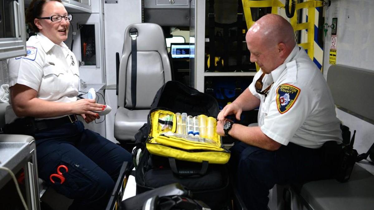 Johnston County paramedics Jennier Peachee and David Crawford sit in the back of an ambulance in Clayton, demonstrating where EMS workers keep the heroin-overdose drug naloxone, May 18, 2016.