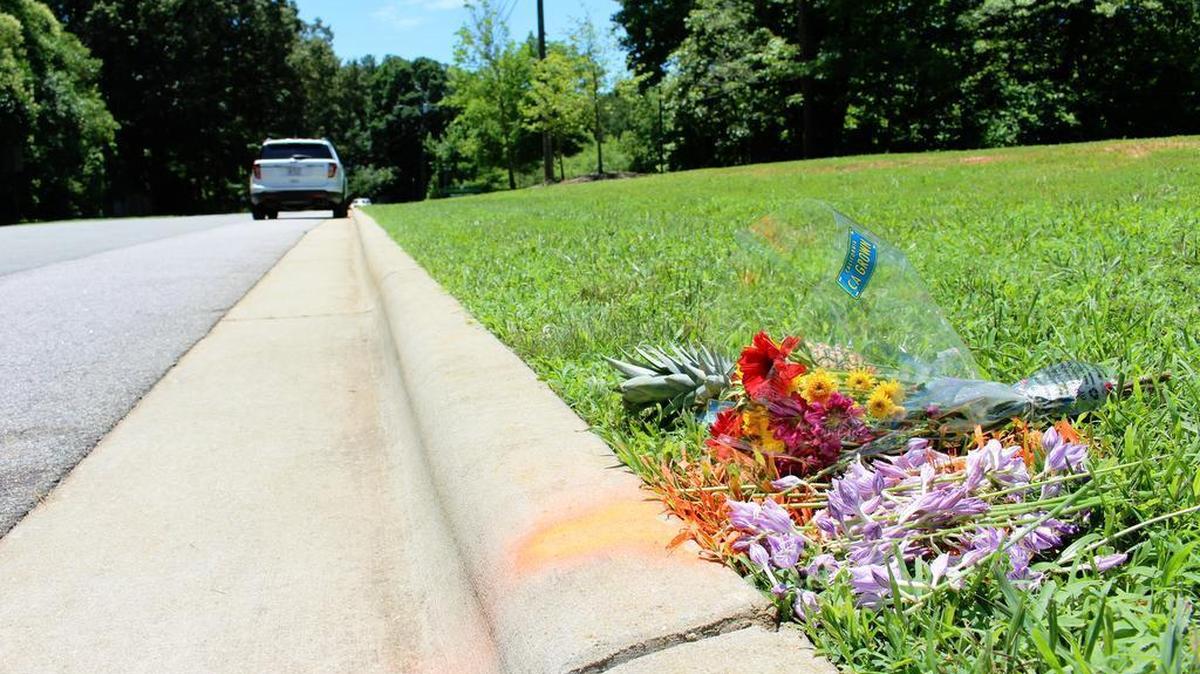 Friends of Katherine Burdick-Crow on Sunday laid flowers and a pineapple at the spot where Cary police say she suffered fatal injuries during an altercation on Friday, June 26, 2015. Four people have been charged with murder in connection with the hit and run.