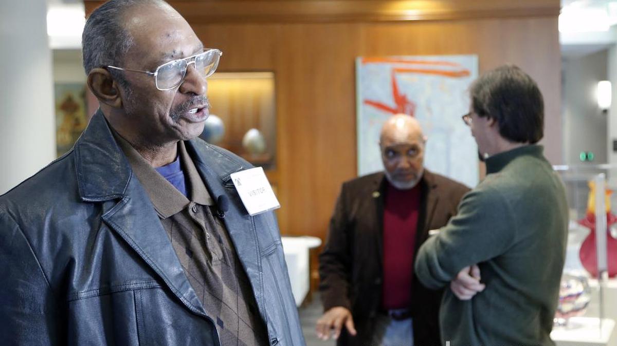 Willie Grimes, left, talks to the media while Larry Lamb, center, and Greg Taylor talk together. All were exonerated of felony charges.