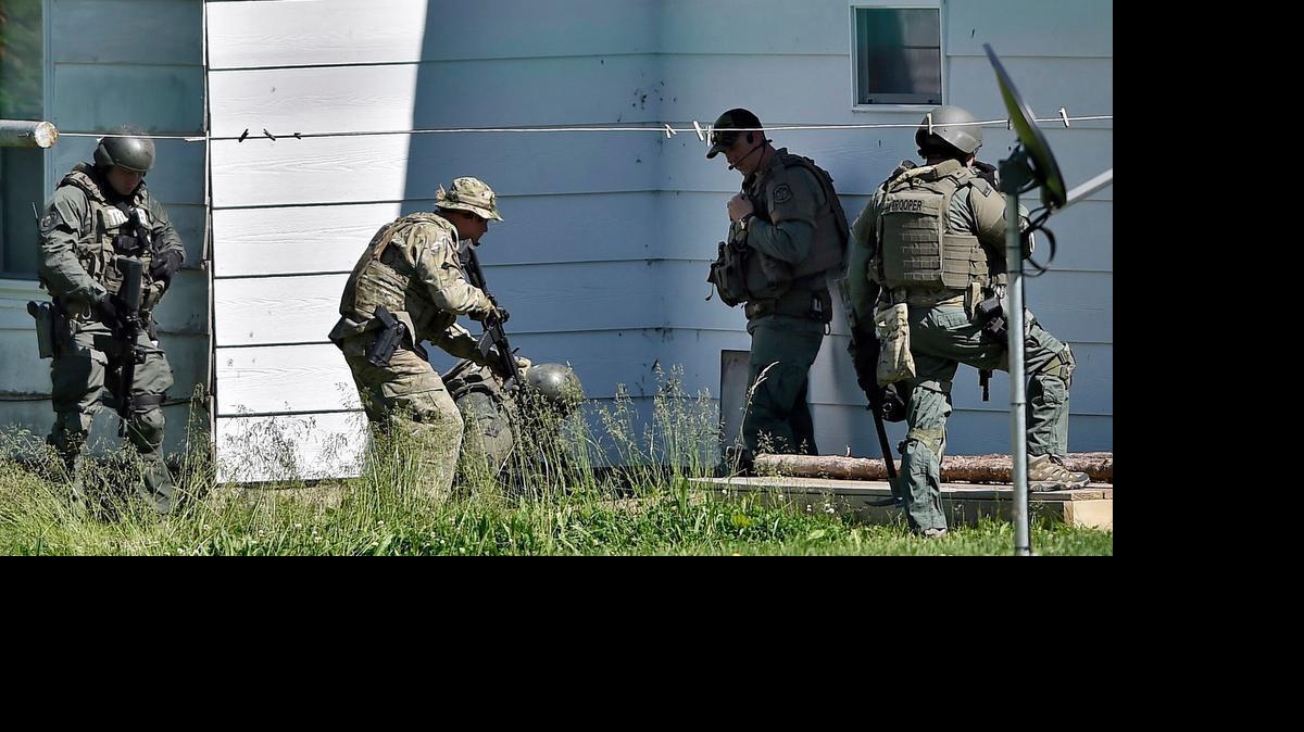 
Completing their search of a property thought to be the location of a suspect in the slaying of Sandra Sutton and Zachary Wade Sutton, Missouri Highway Patrol tactical officers appear to search the cellar of a home on Friday, May 15, 2015, in Sedalia, Missouri. The Suttons were found dead earlier in Clinton earlier in the day. Law enforcement officers found no one during their search. 
