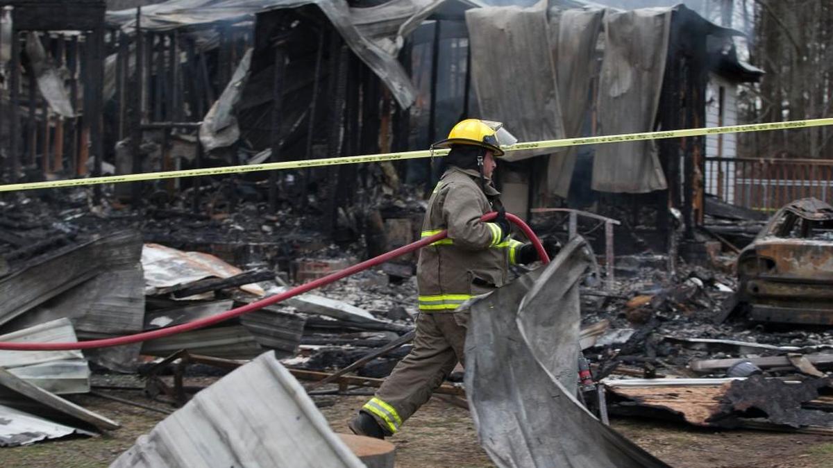 A Cornwall volunteer fireman arrives to extinguish the smoldering remains of the home of Jerome Faulkner, 73, and his wife Dora, 62, on Friday, January 2, 2015, northwest of Oxford, N.C. The Faulkners’ bodies were discovered in their stolen SUV in West Virginia. The SUV was being driven by Eric Alexander Campbell.