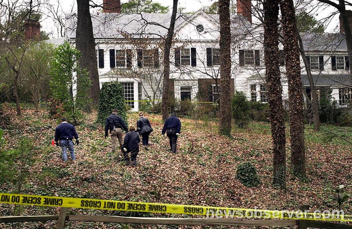 Durham Police officers search for evidence in the front yard of Michael Peterson’s home Dec. 10, 2001. Peterson’s wife, Kathleen Peterson, was found dead at the bottom of a staircase in the home early Sunday morning.