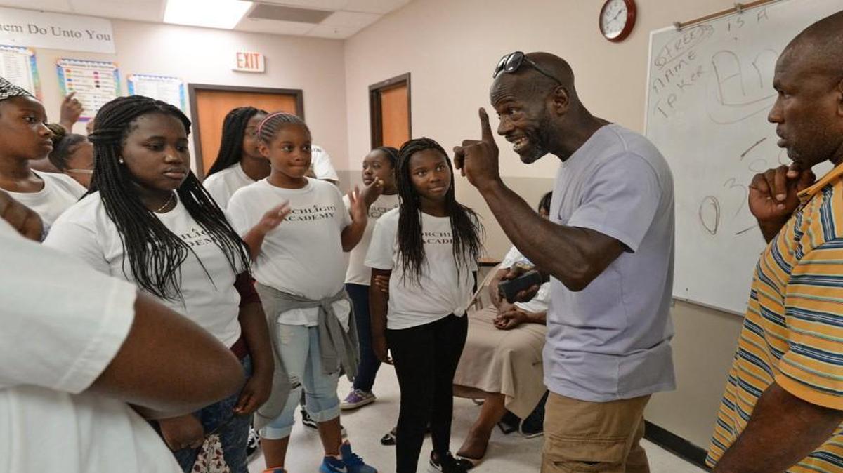 Andre Stevens (center) and Tyrone Hinton (right) speak with students at the Torchlight Academy Summer Camp in Raleigh, N.C. Tuesday, July 19, 2016. Stevens and Hinton, who participated in the gang truce in Raleigh, were cautioning the young boys and girls about the dangers of criminal activity, especially the things that come with being involved in gangs.