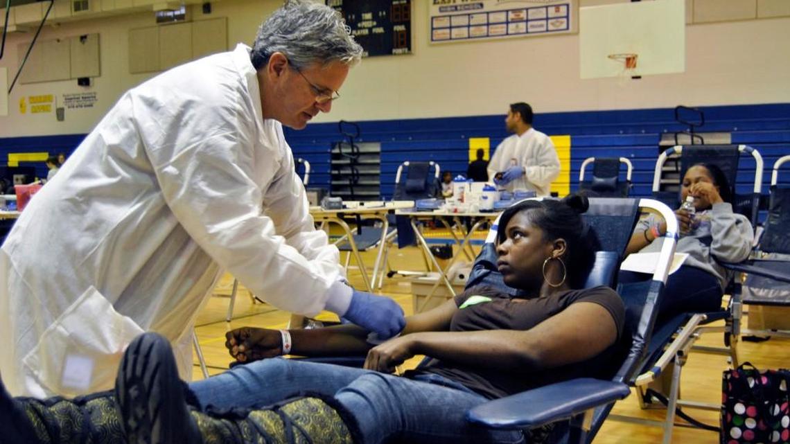 Yolanda Venters is attended to by Red Cross worker Elliott Brown during a blood drive at East Wake High School in 2011.