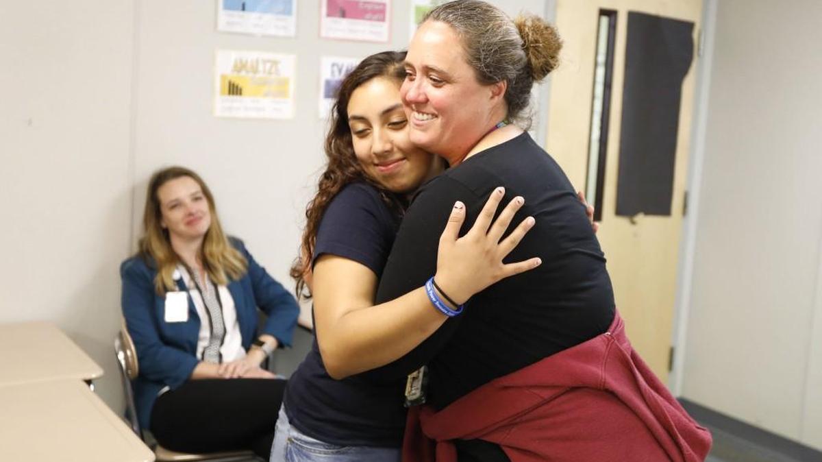 Megan Walter, right, gets a hug from student Emily Paz after Walter was named Wake County’s 2017 School Counselor of the Year.