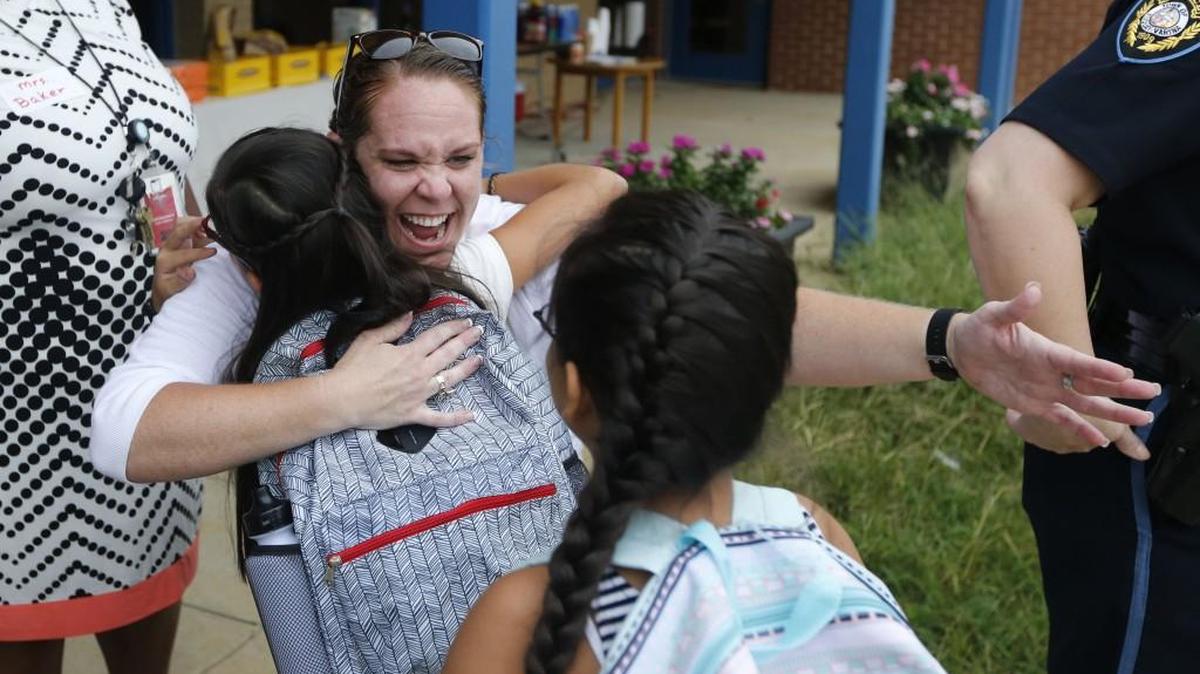 Cathie Linkous, a kindergarten teacher, greets twins Jessica and Jackie Cortez Valdez at Lincoln Heights Elementary School in Fuquay-Varina on Aug. 29, 2016.