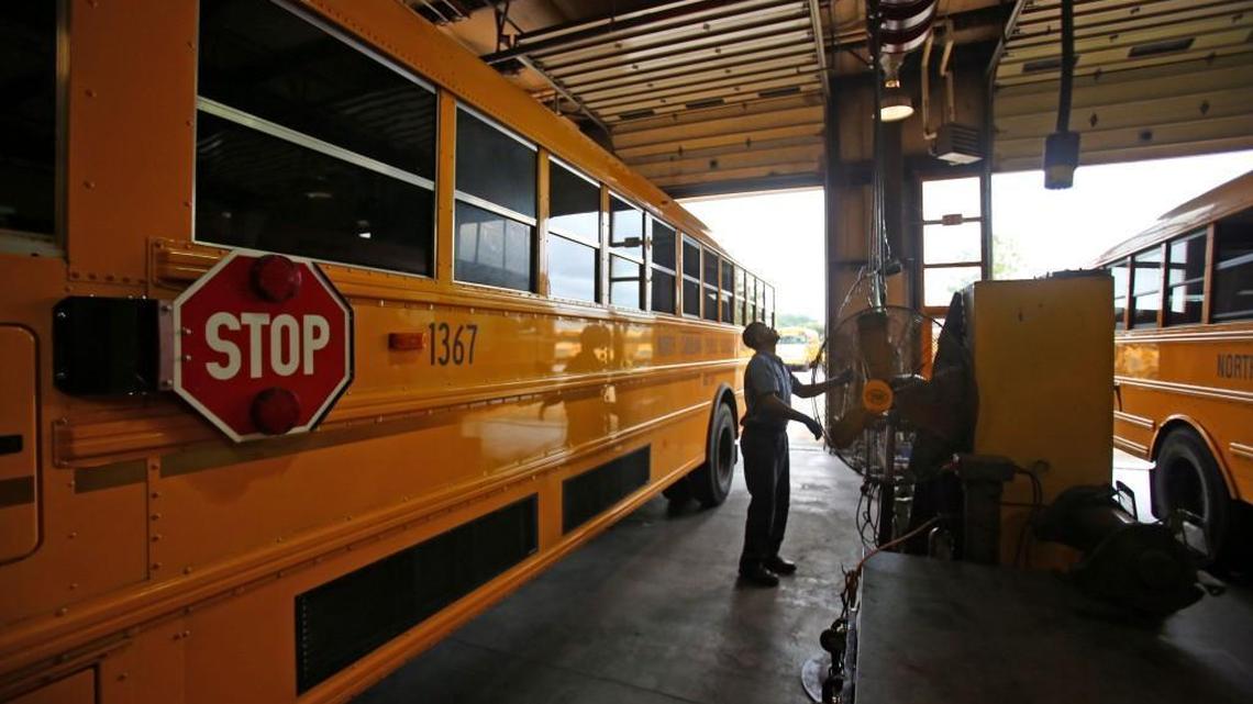 Mechanic Joe Montague retrieves one of his tools while he performs maintenance on a Wake County school bus on Tuesday, August 20, 2013.