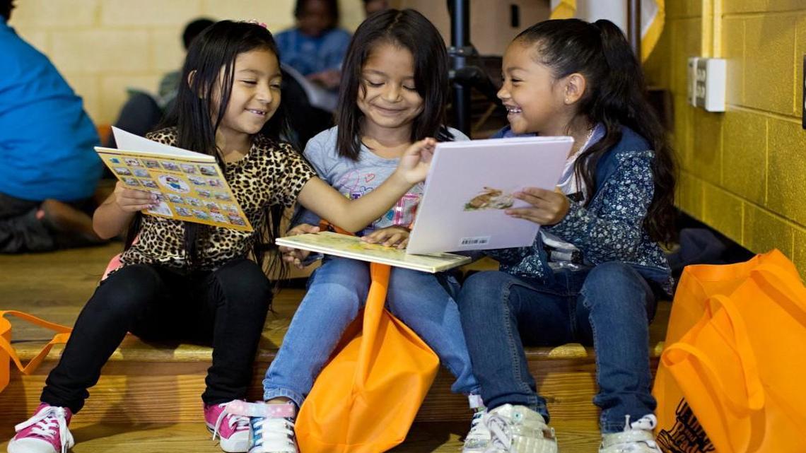 From left, Kelly Morales, 7, Leslye Monterroza, 6, and Joselynne Serrano, 6, read books donated through the 2016 WAKE Up and Read Book Drive during a book fair at Fox Road Elementary School in Raleigh, N.C. Fox Road will again receive books from the 2017 book drive.