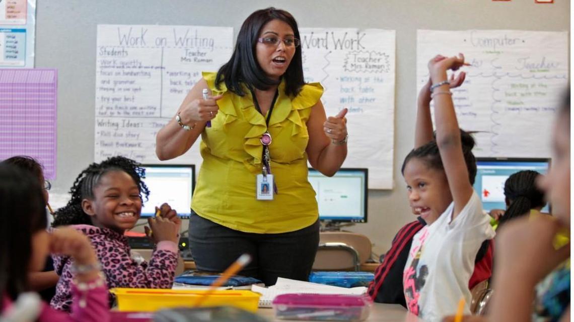 Barwell Road Elementary school teacher Yolanda Roman, standing, gets a reaction from some of her students as she tells her 2nd grade math class students the correct answer to a question involving subtraction on Thursday, March 17, 2016.