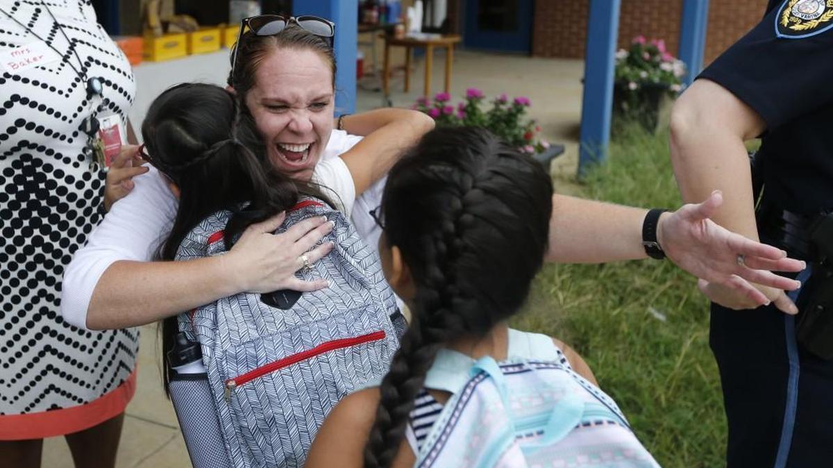 Cathie Linkous, a kindergarten teacher, greets twins Jessica and Jackie Cortez Valdez at Lincoln Heights Elementary School in Fuquay-Varina on Aug. 29, 2016.
