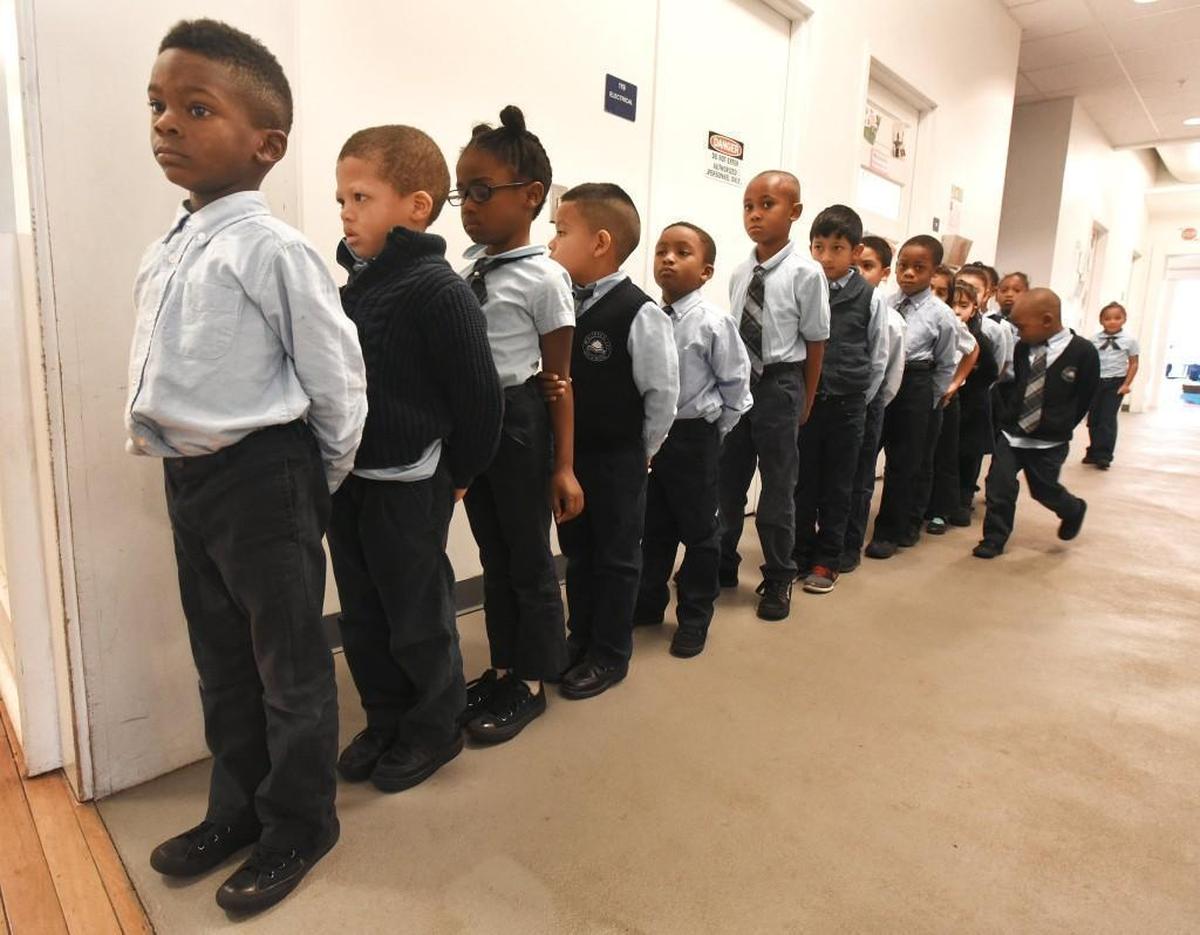 Duvon Blowe, right, carefully checks members of his kindergarten class as they line up to return to the classroom after a morning bathroom break at Maureen Joy Charter School in Durham, N.C. on Dec. 20, 2016. Maureen Joy Charter School is a K-8 public charter school and is tuition free and open to the public.