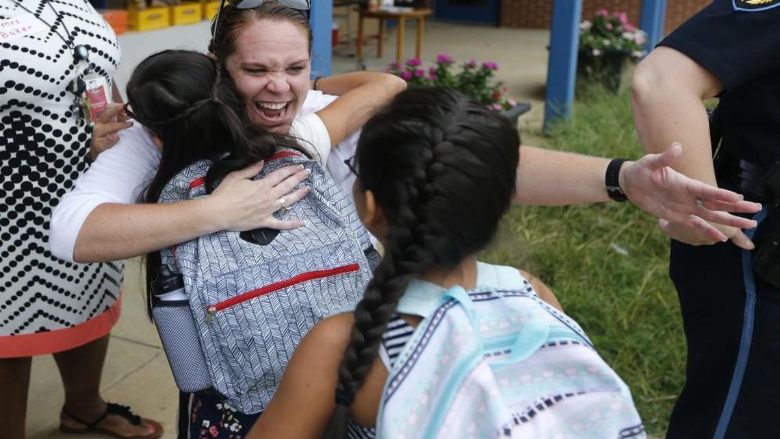 Cathie Linkous, a kindergarten teacher, greets twins Jessica and Jackie Cortez Valdez, right, who are entering fifth grade during the first day of school at Lincoln Heights Elementary School in Fuquay-Varina, N.C., Monday, August 29, 2016. The Wake County school board has voted to make Lincoln Heights a magnet school.