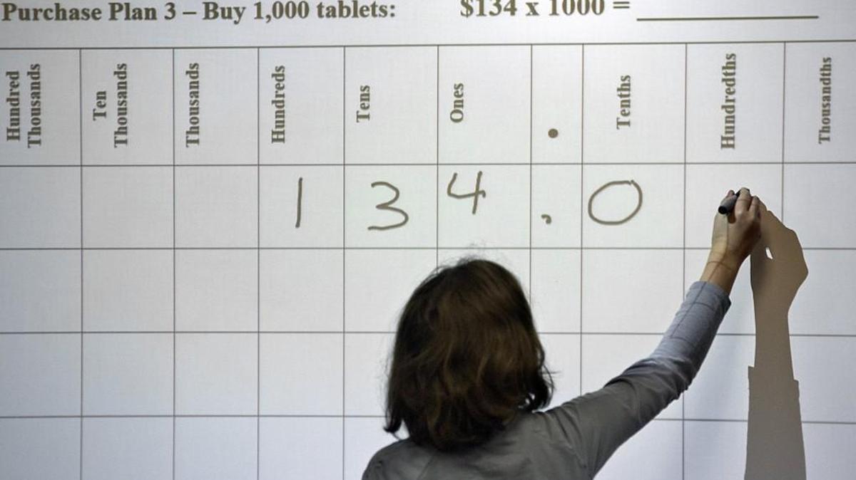 Students, like Miriam Cooper, working a problem at the Smartboard, participate in math problems in Dana Snapp's class at Fuquay-Varina Elementary School. Students there have been using Common Core Math for the past four years. School administrators say it is working for both the students and teachers, while some parents are looking to get rid of it. Rene Herrick, teacher leadership specialist in mathematics at the school, not seen, says the system is important to keep in place.