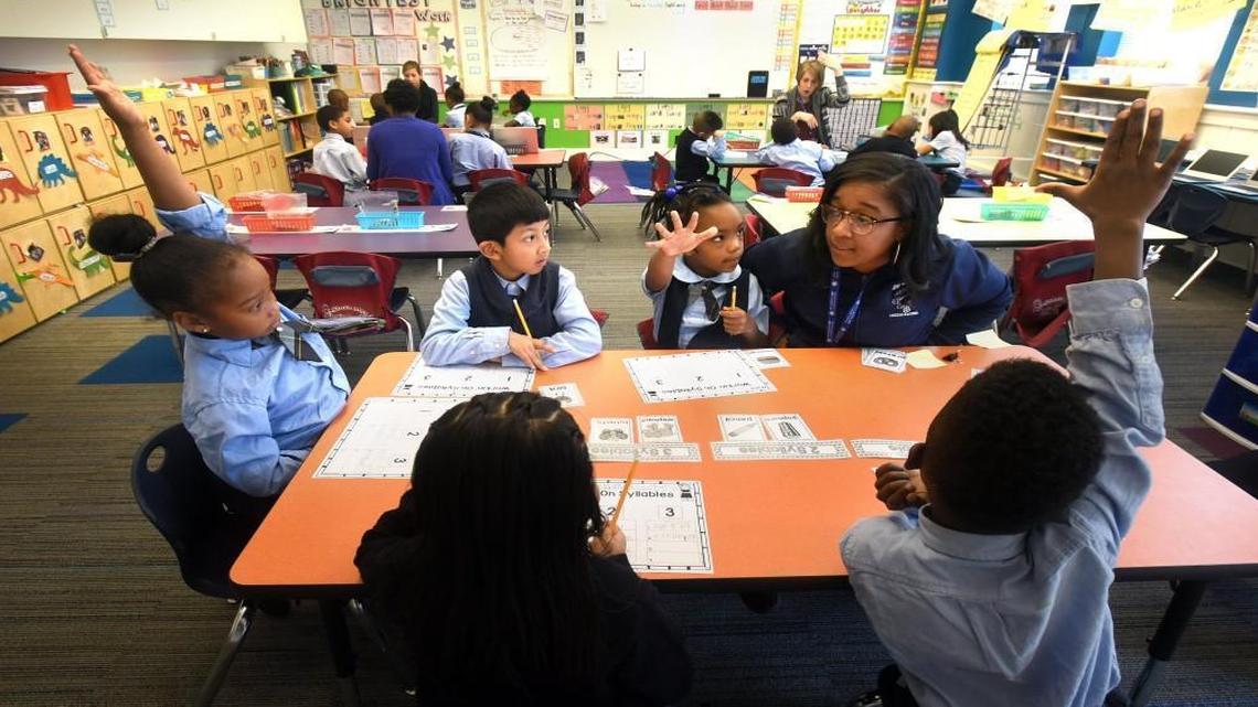 In this file photo, a teacher’s aide, left, works with students during an English lesson at Maureen Joy Charter School in Durham. The K-8 school was one of North Carolina’s first public charter schools.