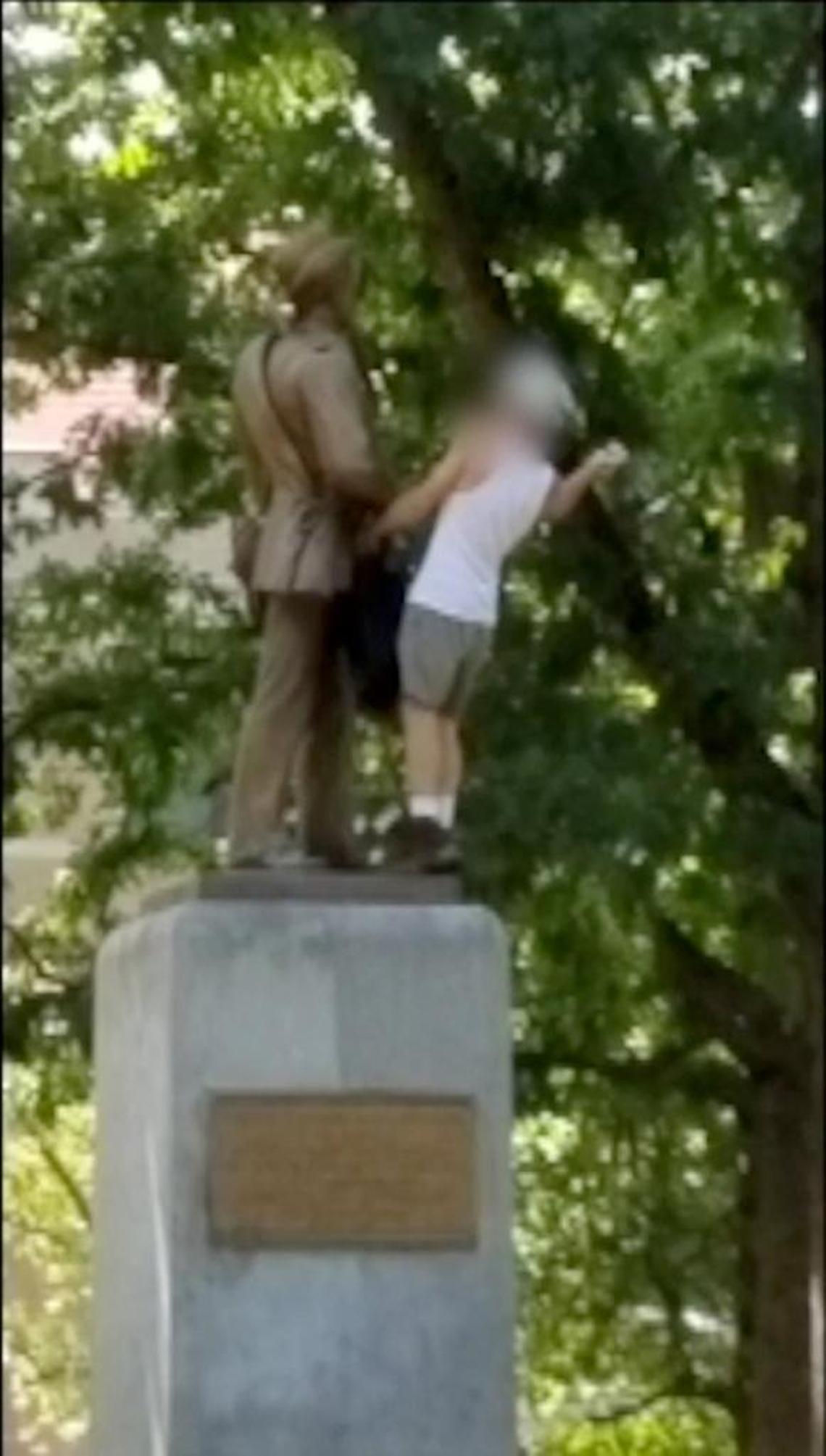 Still image from a video from Aug. 15, 2017, shows an unidentified man hammering the face of the Confederate Silent Sam statue on the UNC campus in Chapel Hill.