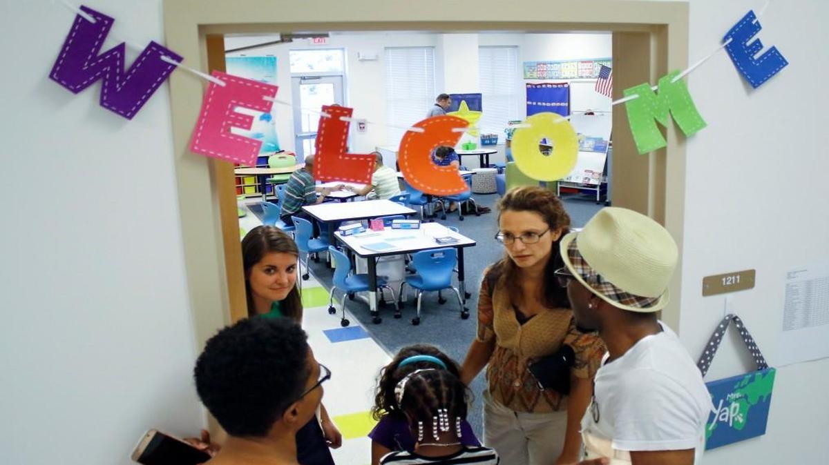Students, parents and 1st-grade teacher Ashley Yap (left background) meet and greet in the doorway to Yap’s classroom in the newly rebuilt Green Elementary School off Six Forks Road, Raleigh, NC, on Aug. 24 2016. The state House has passed a bill that changes the definition of low-performing schools. Under that definition, Green would not have labeled as low performing.