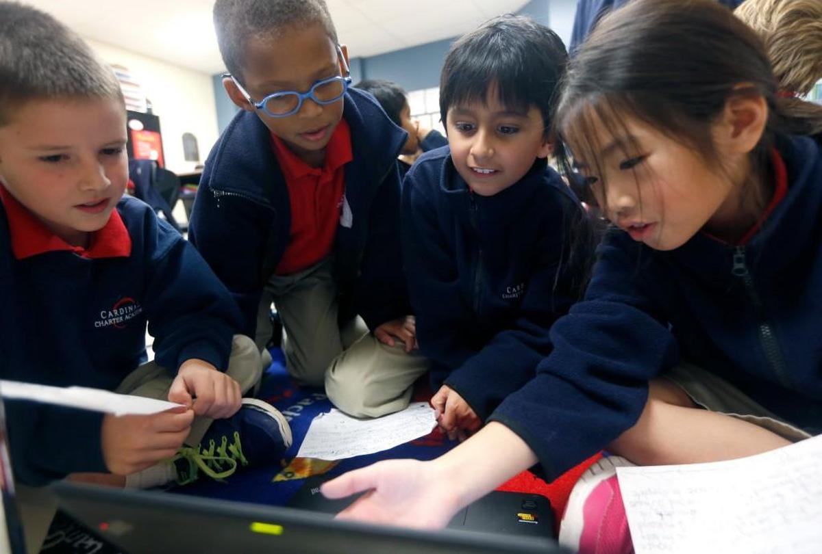 Third graders, from left, Jack McIlhargey, Alexis Trebeau, Krish Babu and Claire Nguyen work on making their own lesson plans at Cardinal Charter Academy in Cary, N.C., on Dec. 2, 2015.