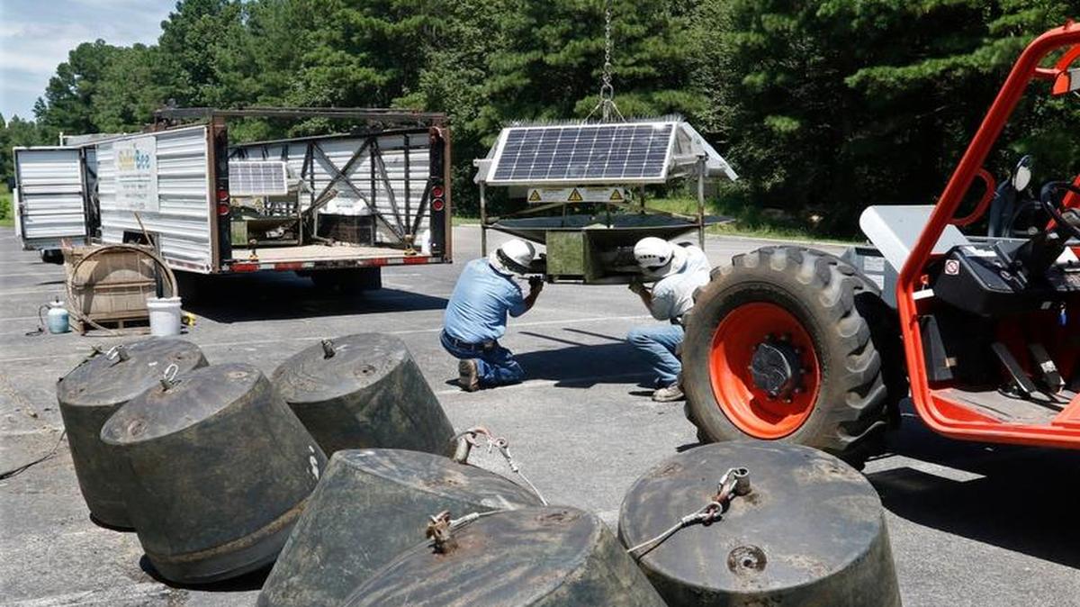 SolarBee floating anchors, foreground, await loading as SolarBee employees Steve Shanabarger, left, and Cody Lague disassemble a SolarBee core unit August 11, 2016 at Farrington Point boat ramp at Jordan Lake in Chatham County. Twenty four of the SolarBee reservoir circulators were installed in the northern part of Jordan Lake in hope of reducing algae blooms in July 2014 but were found by the NC Department of Environmental Quality to be ineffective. The units in the northern part of Jordan Lake were being collected and disassembled for removal back to North Dakota this week. Shanabarger said that the remaining 12 SolarBee units in the Haw River at Robeson Creek landing will be removed next week.