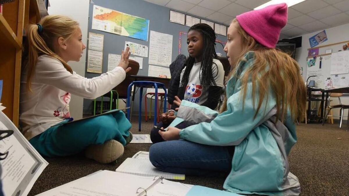 Washington Elementary School student Averye Morrison (left) works with friends Kayla Lewis (center) and Pearl Hollingsworth on a math problem in class in December.