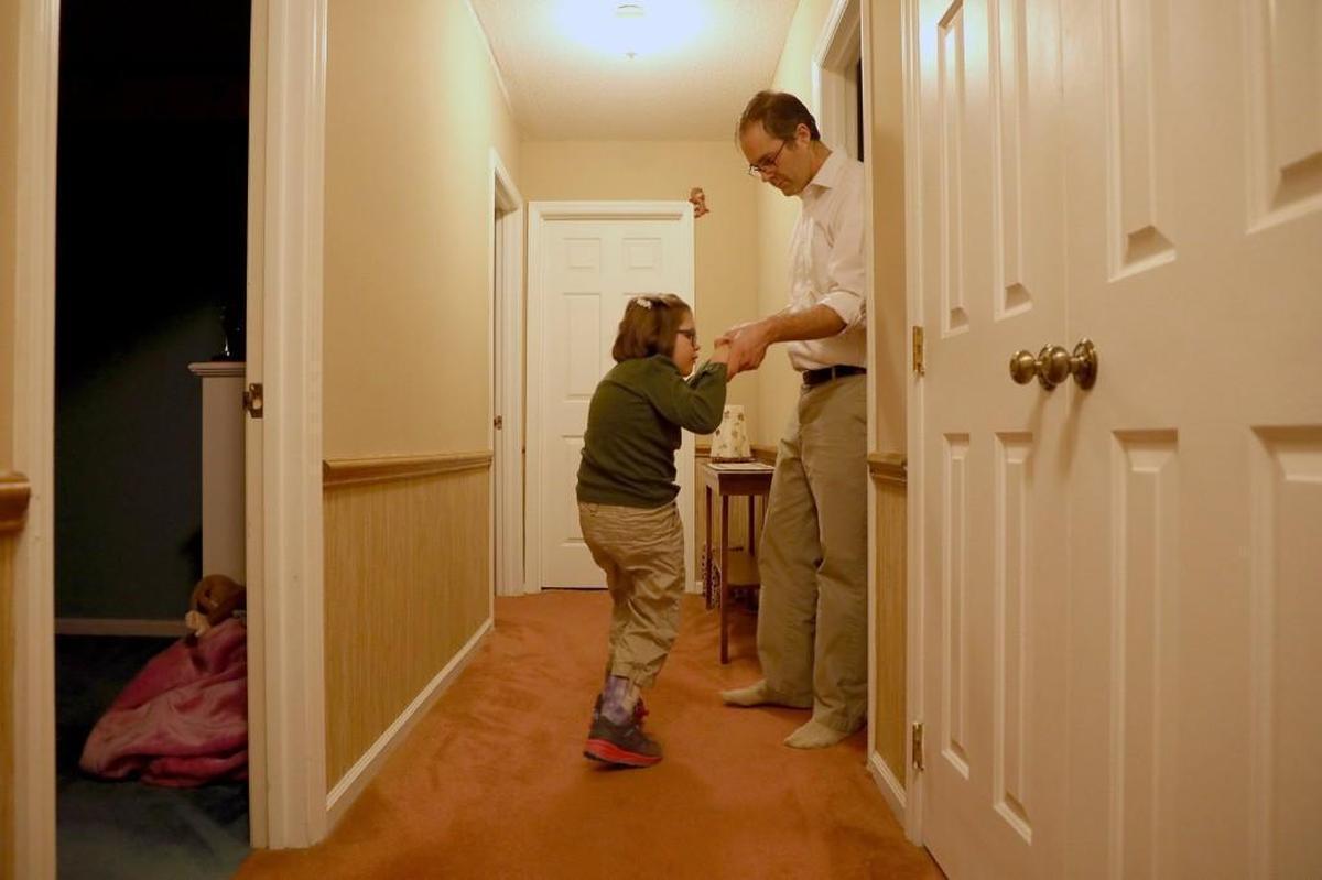 Cyrus Bradford helps his daughter, Libby, 8, who suffers from a rare genetic condition, walk to the bathroom before bedtime on Thursday, Jan. 25, 2018, in Durham.