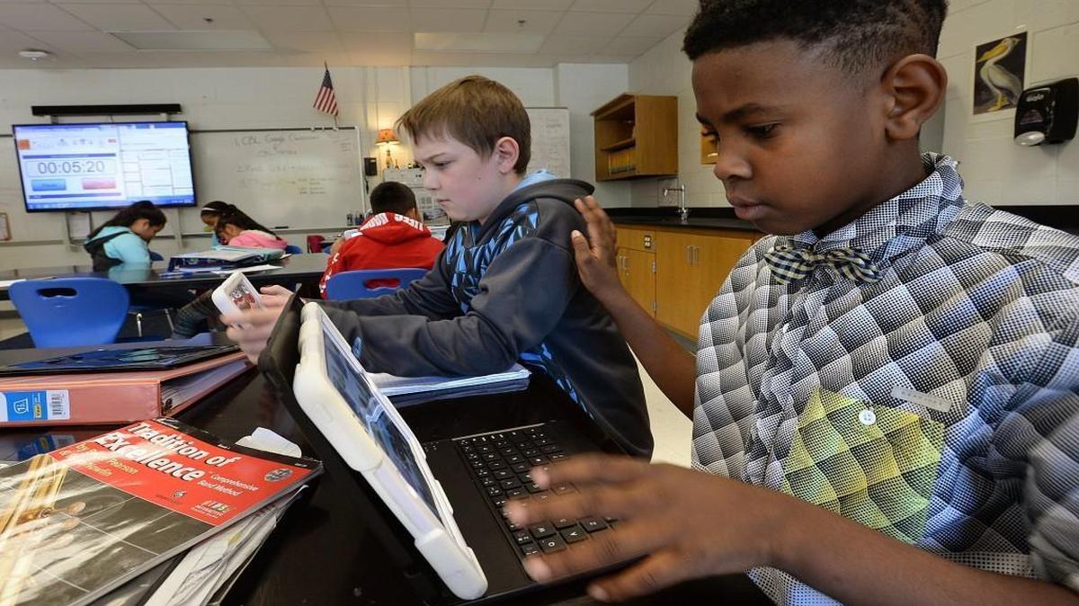 Sixth-grader Jakari Garner, right, asks classmate Nate Guenzler for help during their science class at Carroll Middle School in Raleigh, N.C., Tuesday, Oct. 25, 2016.