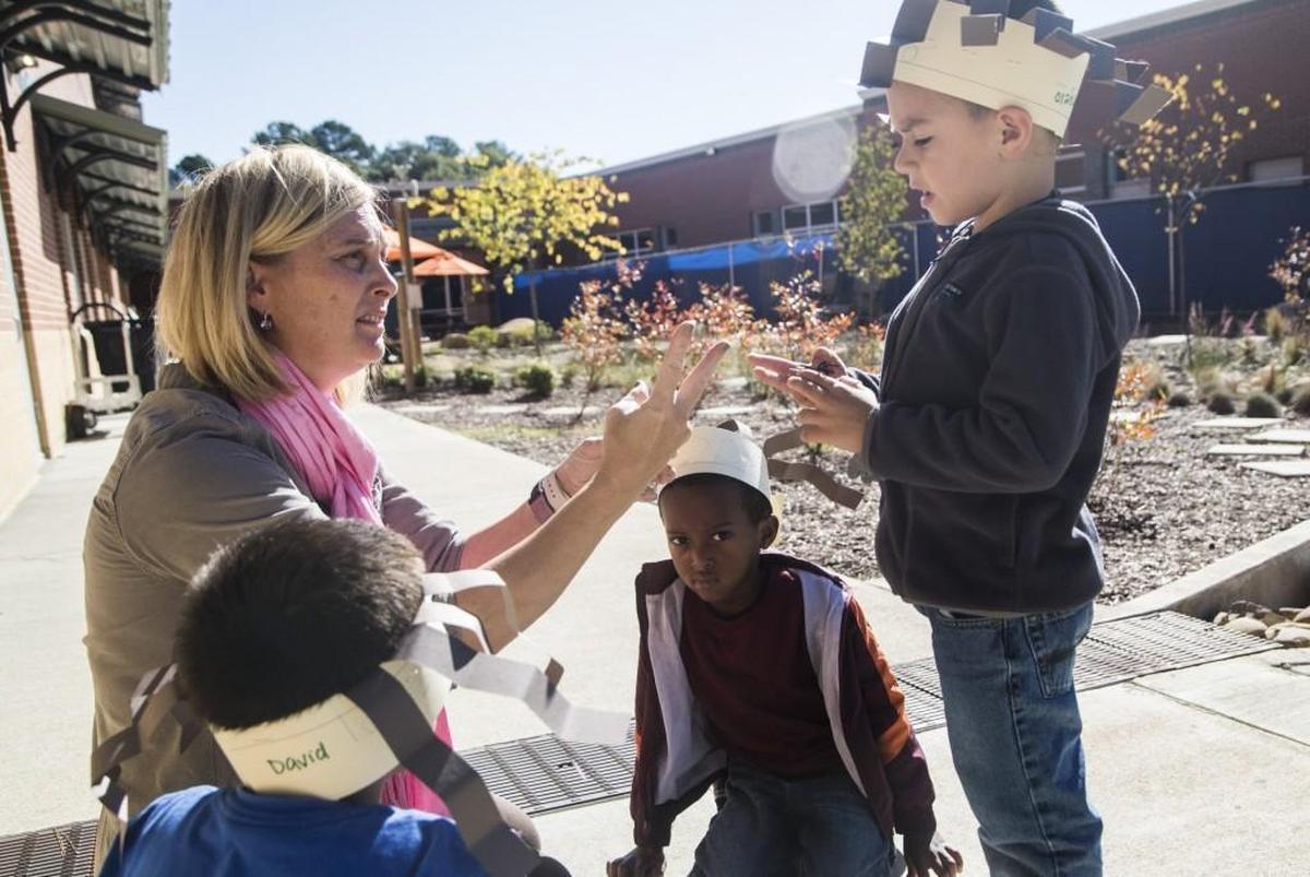 Christianne Stooks, an environmental inquiry specialist specialist, left, counts plastic spiders with pre-k student Angelo Cruz during an outdoor lesson at Lincoln Heights Elementary School in Fuquay-Varina Wednesday, Oct. 26, 2017.