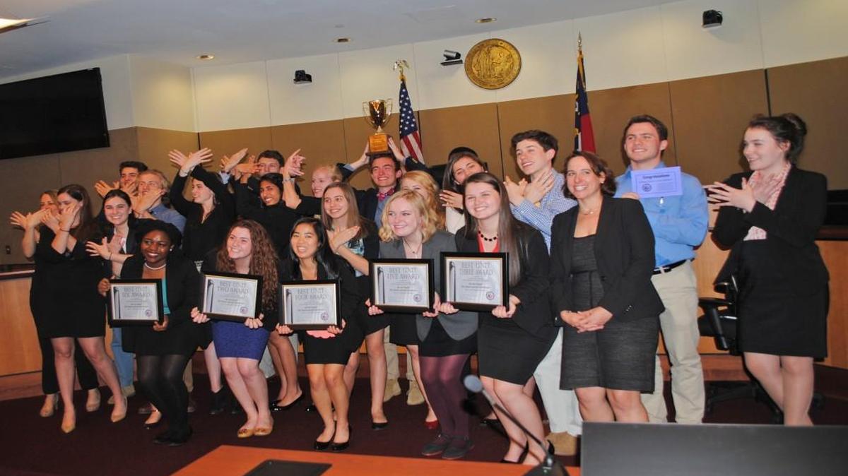 Members of Raleigh Charter High School's winning “We the People: The Citizen and the Constitution” team make the school's signature Phoenix hand signal.