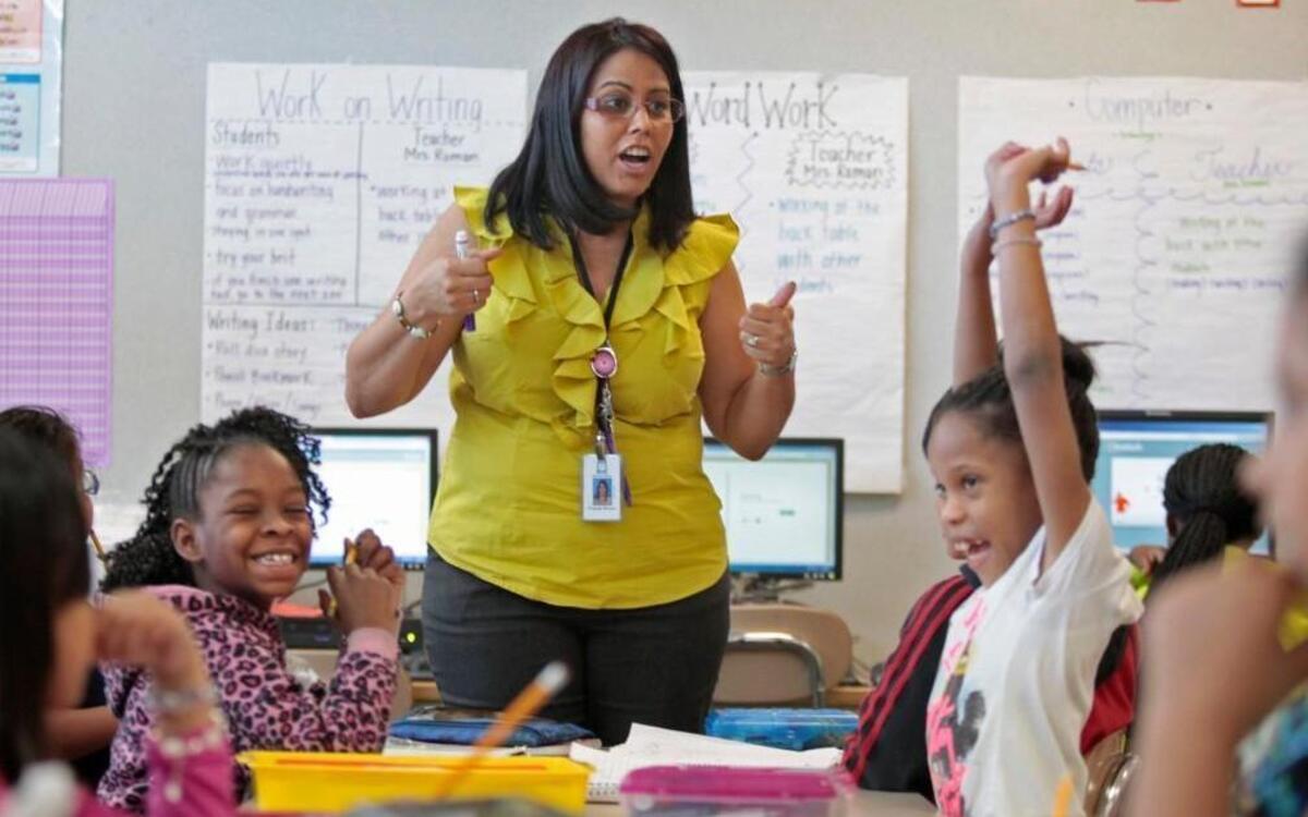 Barwell Road Elementary school teacher Yolanda Roman, standing, gets a reaction from some of her students as she tells her 2nd grade math class students the correct answer to a question on subtraction with 10s and 100s during math period in Roman's homeroom Thursday, March 17, 2016.