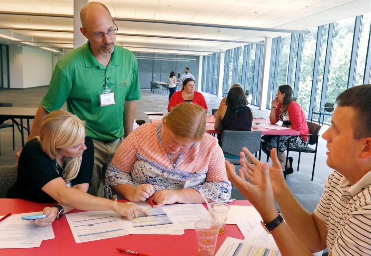 From left, Wake County teachers Katey Long, Brian Cole and Elizabeth Crowell work through a multi-faceted Design and Innovation interactive game of product development advised by LORD Corporation facilitator Mark Tate as part of the WakeEd Partnership’s SummerSTEM program in this 2016 file photo. WakeEd is launching a similiar effort for high school students called Career Accelerator.