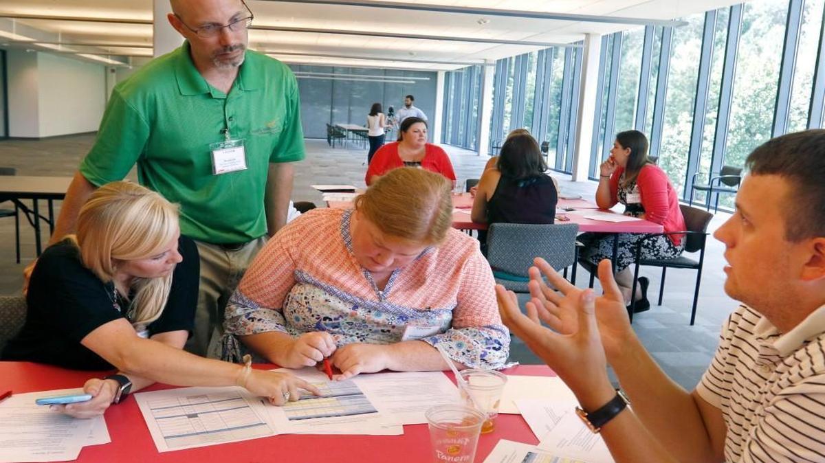 From left, Wake County teachers Katey Long, Brian Cole and Elizabeth Crowell work through a multi-faceted Design and Innovation interactive game of product development advised by LORD Corporation facilitator Mark Tate as part of the WakeEd Partnership’s SummerSTEM program in this 2016 file photo. WakeEd is launching a similiar effort for high school students called Career Accelerator.