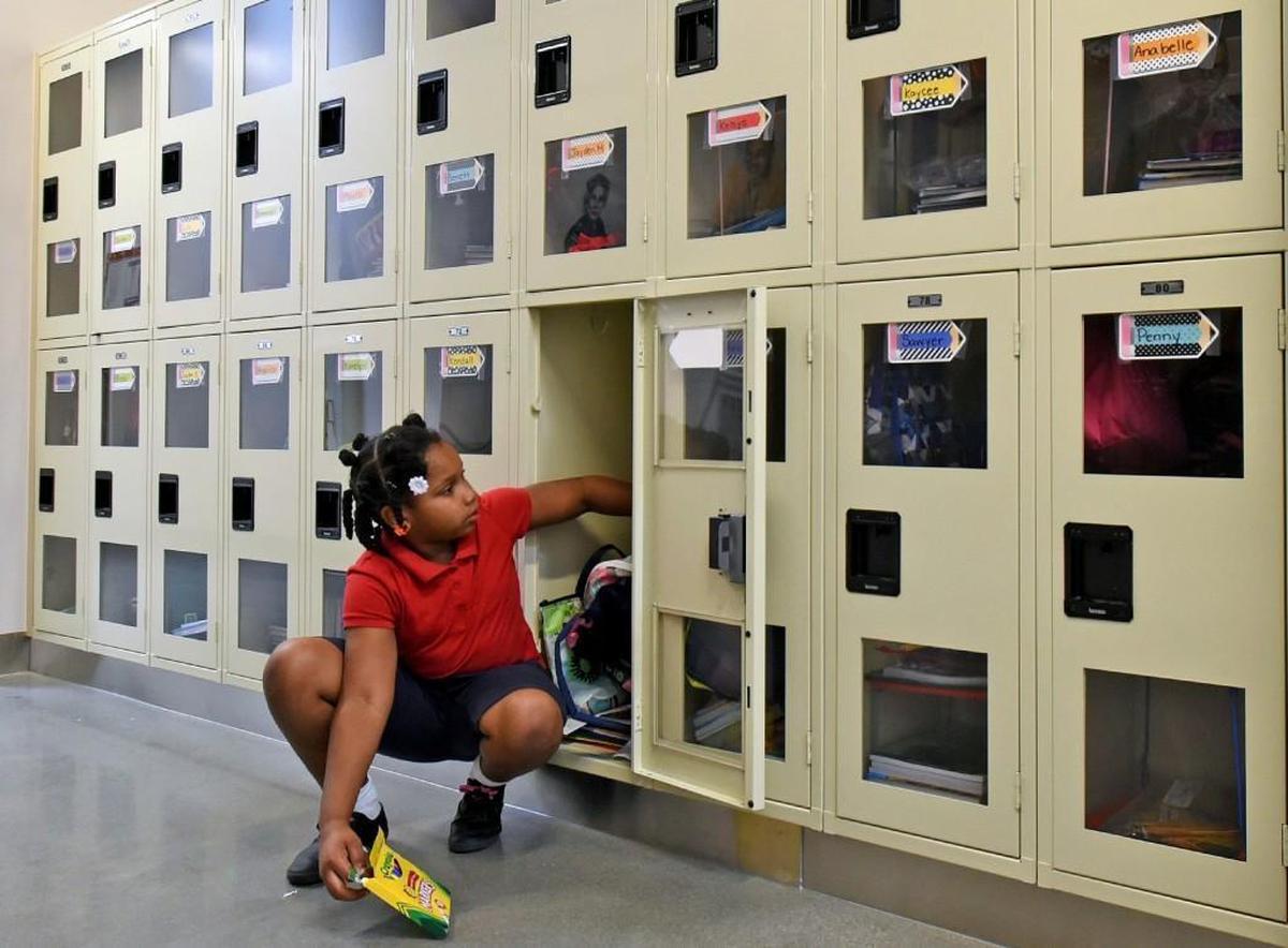 Mirakle Jones,7, retrieves a book from her locker at Thales Academy in Knightdale, N.C. Thursday, July 20, 2017. Traditional public schools in North Carolina are now seeing a drop in enrollment at the same time that home schools, charter schools and private schools like Thales are seeing enrollment gains.