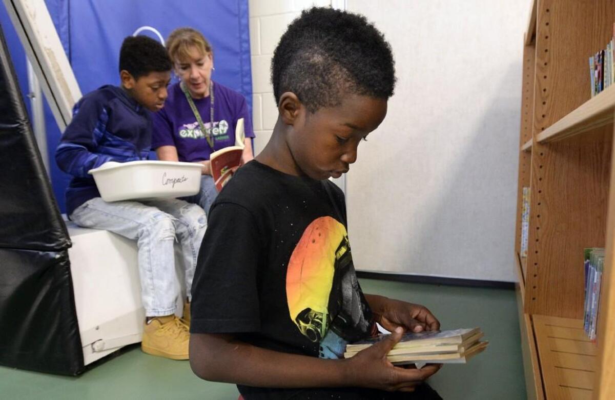 East Garner Elementary School reading teacher Kathy Trabucco (center) helps Jamir Vaughn (left) pick out books as classmate Justin Darden (right) does the same during the WAKE Up and Read event in Garner, N.C., Thursday, May 11, 2017. The program in its fourth year and distributes over 112,000 books to 10 Wake County elementary schools and 20 childcare facilities. Children are given baskets and allowed to pick out 10 books each. Many of the students get books for siblings or friends too.
