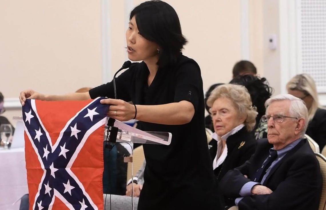 Heather Redding, 39, an Orange County resident married to a UNC graduate, holds up a Confederate Battle flag as she urges the UNC-Chapel Hill Board of Trustees to remove the controversial statue "Silent Sam" at UNC-Chapel Hill, Wednesday, November 15, 2017.