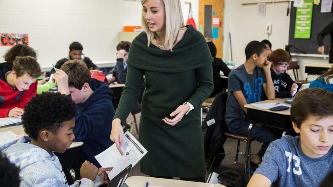 Durant Road Middle School teacher Alyssa Jackson helps seventh-grader Tyson Hill during a lesson on statistics analyzing NCAA mens basketball seeds in the NCAA championship tournament in a file photo from Thursday, March 16, 2017.