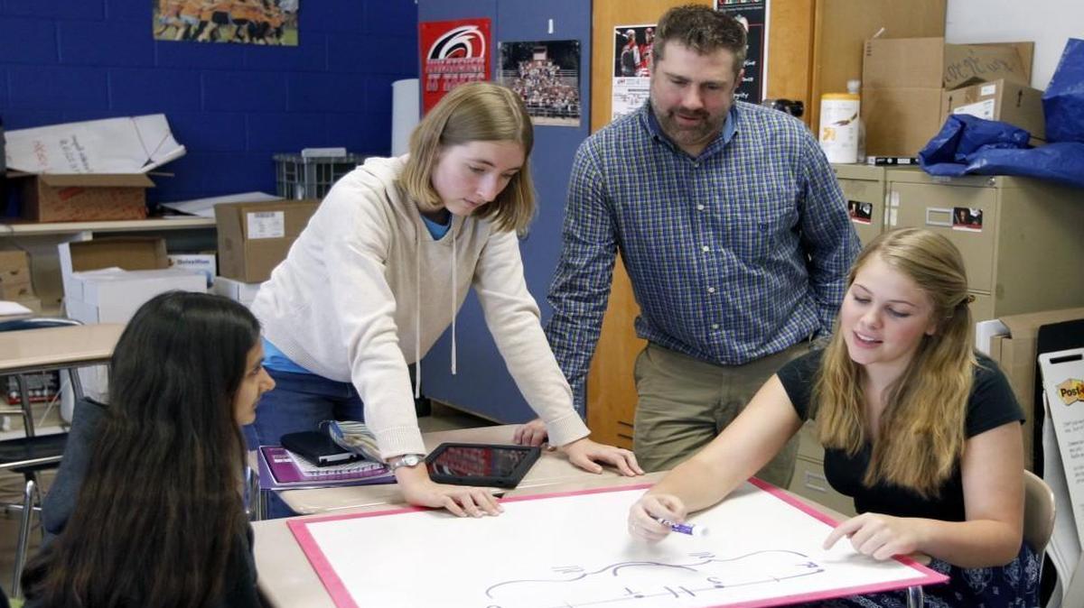 
Students Kopal Gupta, left, Laurel Thomas, left center, and Karlyn Voltz, right, work on a problem as teacher Scott Maxwell, right center looks on in his Math III Honors STEM class at Athens Drive High School in Raleigh on Sept. 15, 2015.

