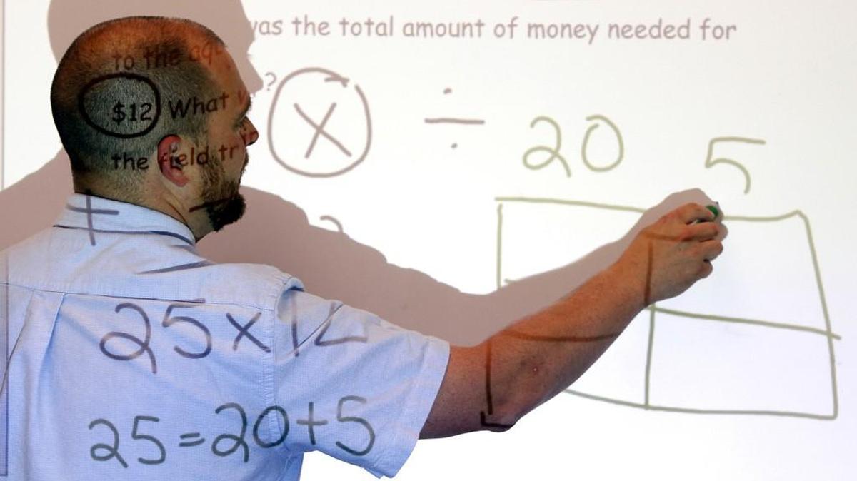 Fourth grade teacher Brian Pattison works on a math problem for his students at the Lake Myra Elementary School in Wendell, N.C.