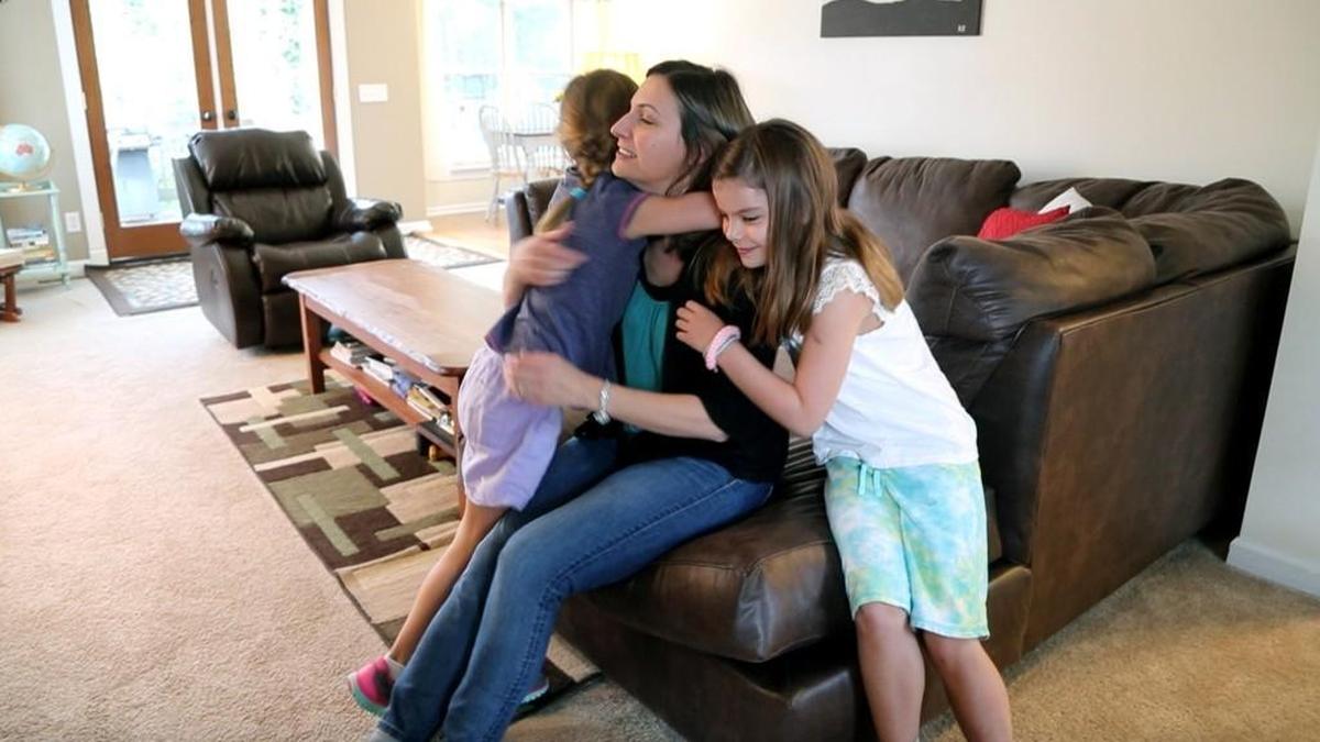 Kristin Riha, center, hugs her two daughters before she takes them to Willow Springs Elementary School while at their home in Fuquay-Varina, NC, on Sept. 29, 2017. Riha is concerned that a proposed Wake County school reassignment plan will have her two daughters, two grades apart, going to different schools. One would be on a traditional calendar year schedule; the other on year-round.