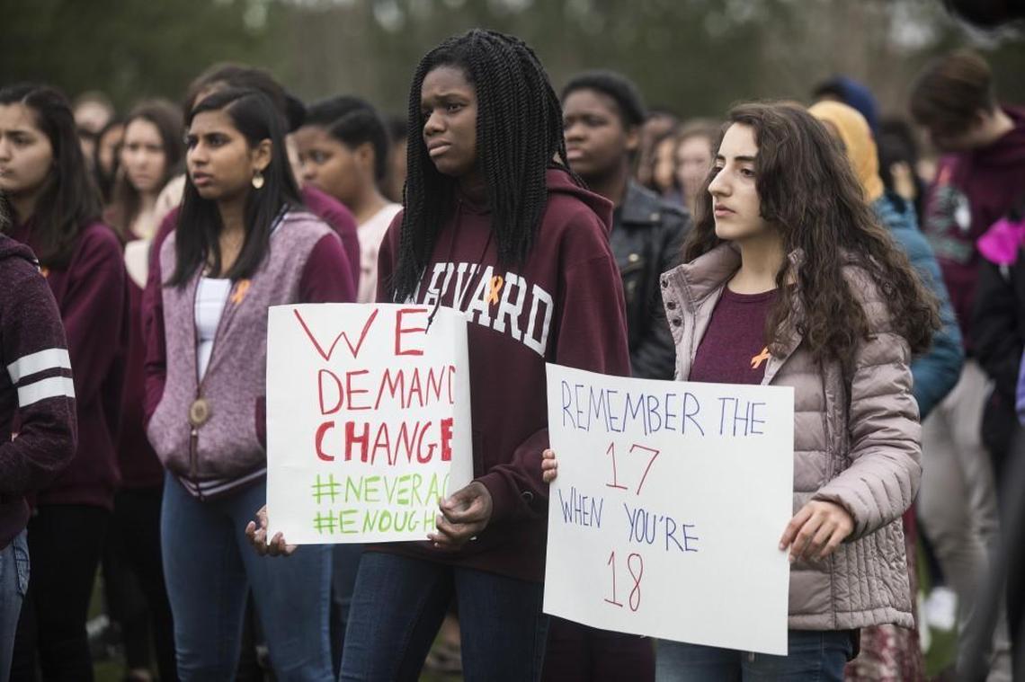 Green Hope High seniors Kayla Blades, left, and Seena Arafat hold signs as more than 2,000 students walked out of Green Hope High School in Cary on Wednesday, Feb. 28, 2018 to demand political changes to try to end school gun violence following the recent Florida school shooting massacre.