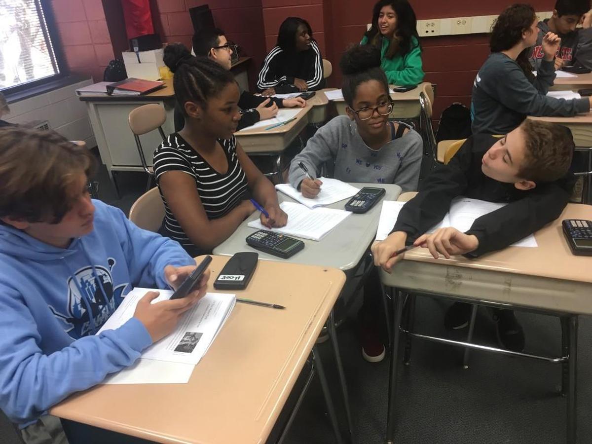 (From left to right) Eighth-grade students Tiernan Flood, Kaudia Williams, Jade Daniels and Alex Bica talk through a math problem at Leesville Road Middle School in Raleigh, N.C. on Nov. 13, 2017.