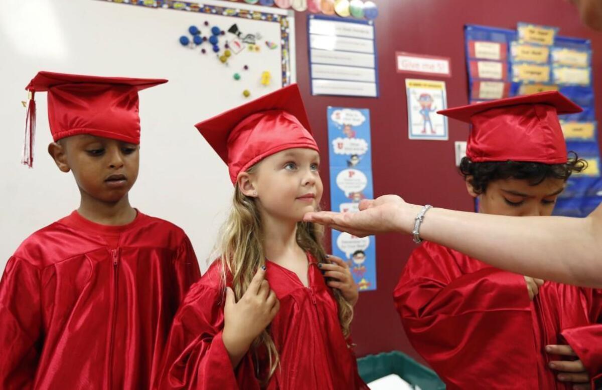 Annabel Cross gets help from teacher's assistant Lisa Kidder before the kindergarten graduation ceremony at Triangle Math and Science Academy in Cary, Wednesday, May 31, 2017.
