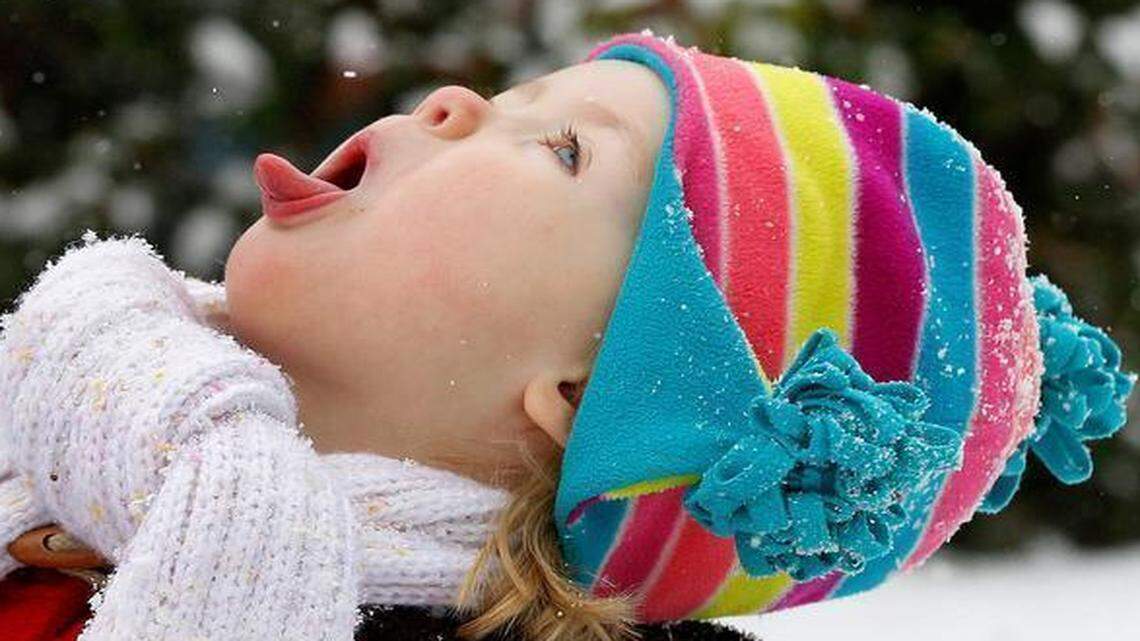 
Nina Woomer-Deters, 2, catches snow on her tongue outside her home in Raleigh on Feb 24.
