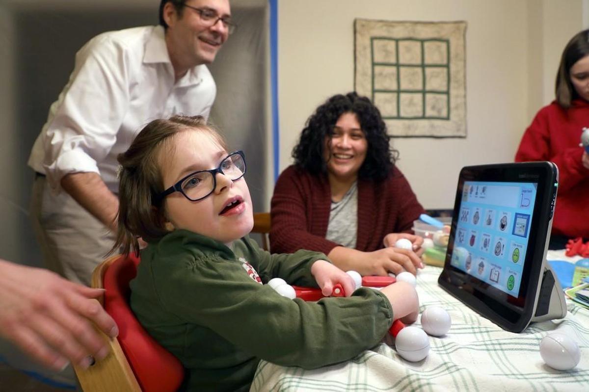 Libby Bradford, 8, who suffers from a rare genetic condition, sits at the dinner table with her family and uses a specialized device to communicate through her eye movements on Thursday, Jan. 25, 2018, in Durham.