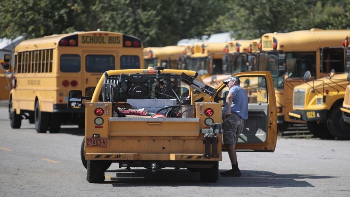 Mechanics stop to talk briefly while prepping Wake County school buses in the Wake County Public School System transportation facility in southeast Raleigh Thursday, August 25, 2016 for the opening of the traditional school year next Monday in Wake County. Wake has taken 60 more school buses off of the roads this fall due to more efficient bus routes, a shortage of bus drivers and cost cuts.