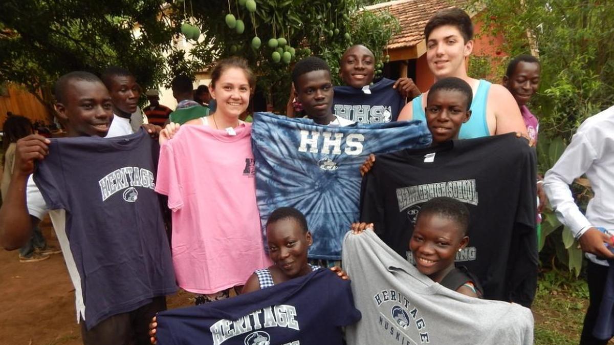 Students from Heritage High School in Wake Forest share some school T-shirts with students from Wisdom Academy during a trip to Ghana in 2016.