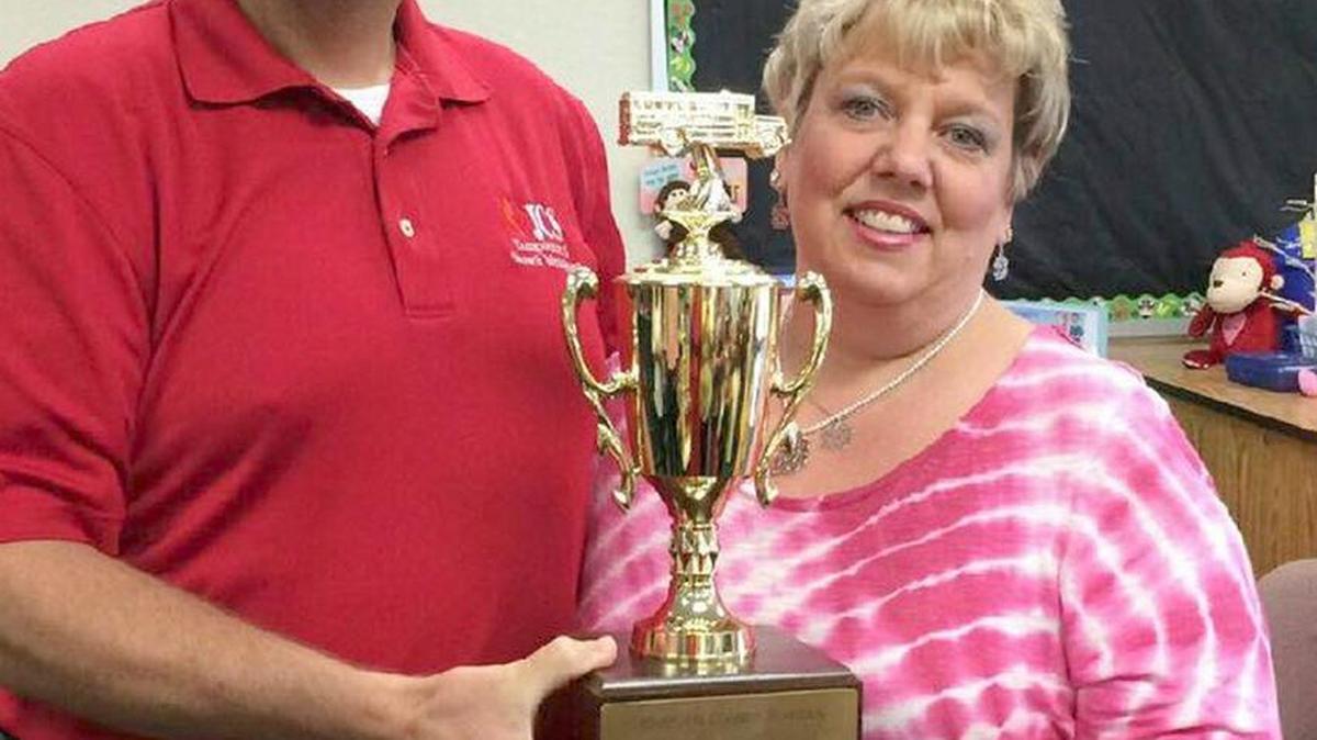 Shannon Brock, right, accepts the 2015-16 Driver of the Year award from Michael Taylor, the school system’s director of transportation services and growth planning.